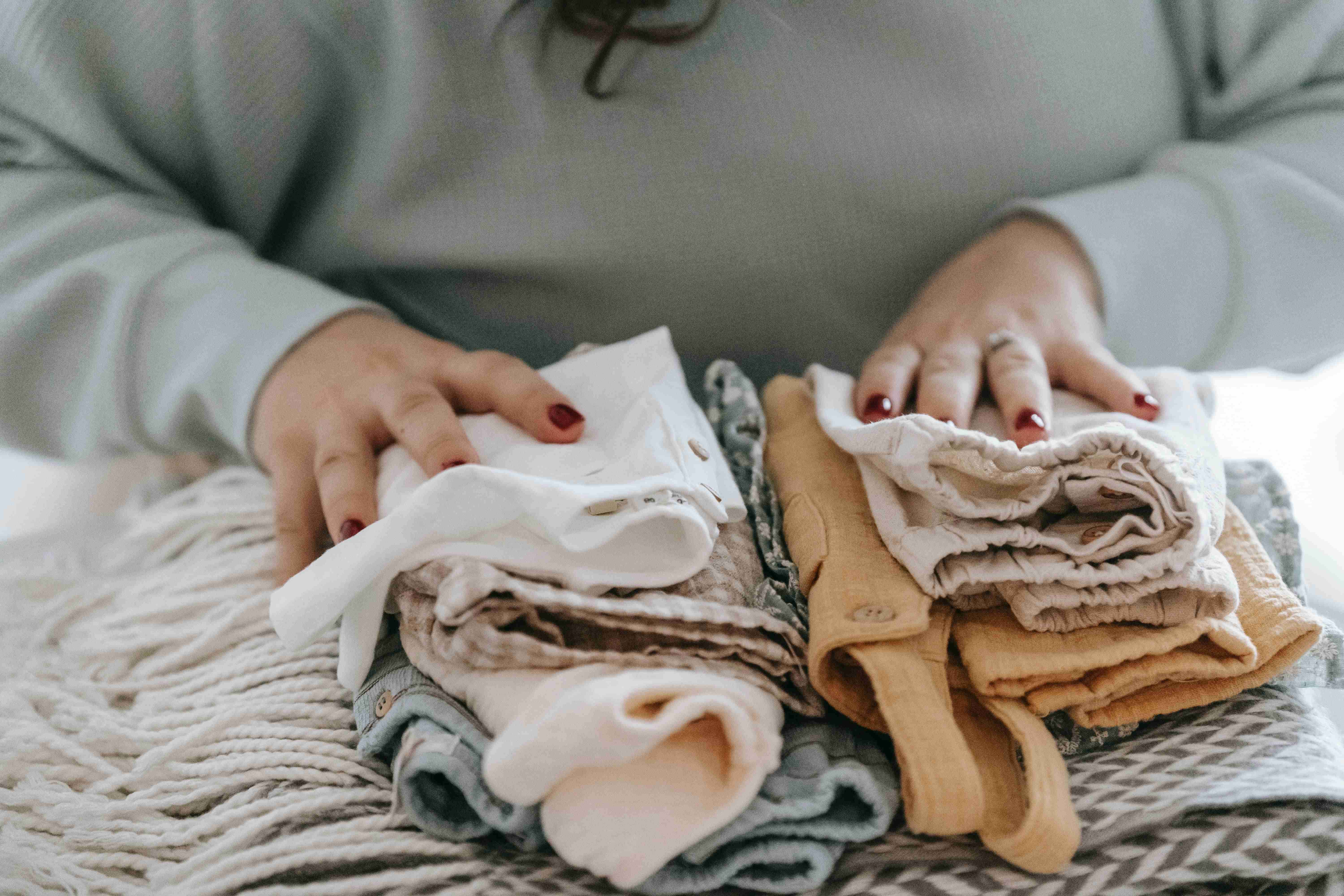 a lady folding baby clothes